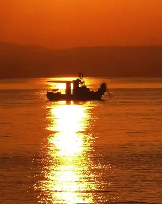 a boat in the water with a sunset in the background at Villa Elena Gardens in Ayia Napa