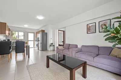 a living room with a purple couch and a table at Downtown 2 Bedroom Apartment in Larnaka
