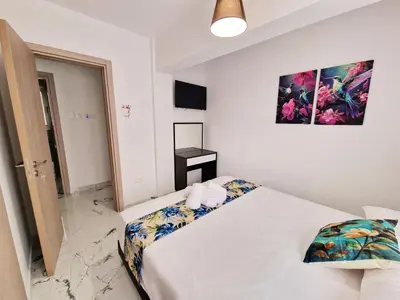 a bedroom with a bed and a painting on the wall at Parrots Paradise 100m from Finikoudes beachfront in Larnaka