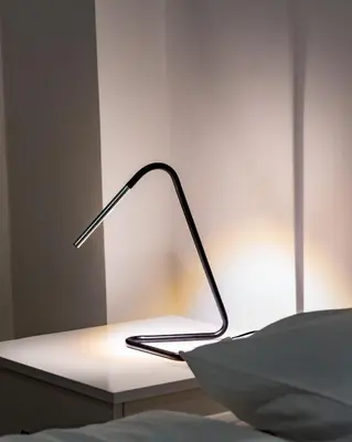 a lamp sitting on a table next to a bed at Earth Apartment in Larnaka