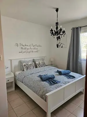 a bedroom with a bed with a chandelier above it at Mediterranean Sunrise Apartments A1 in Voroklini
