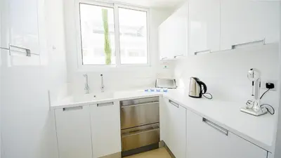a white kitchen with a sink and a window at Protaras Holiday Villa 100 in Protaras