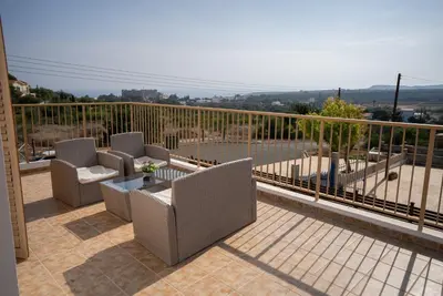 a patio with chairs and a table on a balcony at Konnos Villa 1 in Protaras
