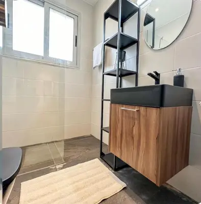 a bathroom with a sink and a mirror at Neptune Apartment in Larnaka