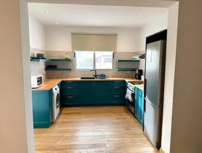 a kitchen with blue cabinets and a sink at Neptune Apartment in Larnaka