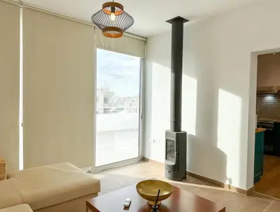 a living room with a couch and a fireplace at Neptune Apartment in Larnaka