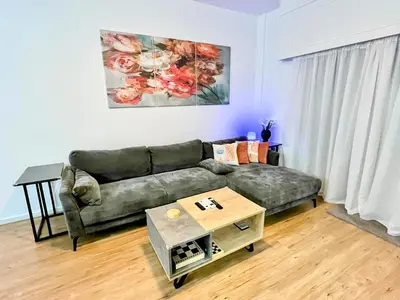 a living room with a couch and a table at Modern apartment near McKenzie beach in Larnaka
