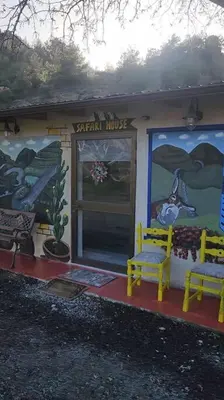 a small house with two yellow chairs in front of it at Safari House with fireplace in Agros
