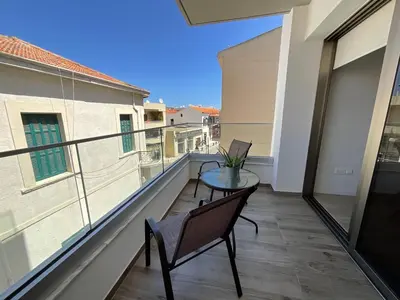 a balcony with a table and a view of a building at Le Voyageur II in Larnaka