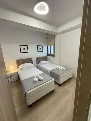 a bedroom with two beds and a mirror at Le Voyageur II in Larnaka