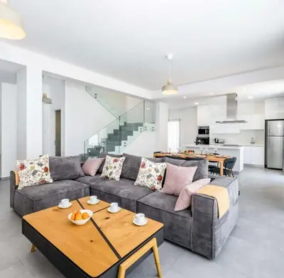 a living room with a couch and a table at By the beach Villa 2 in Protaras