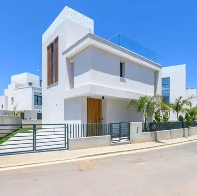 a white house with a fence in front of it at By the beach Villa 2 in Protaras