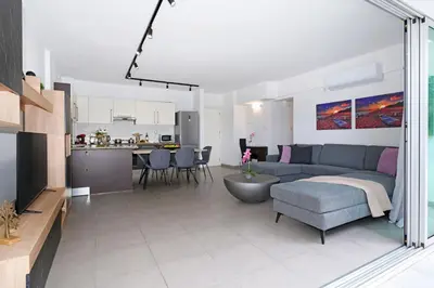 a living room and kitchen with a couch and a table at Alessia 2bed Apartment - Coralli Beachfront Resort in Protaras