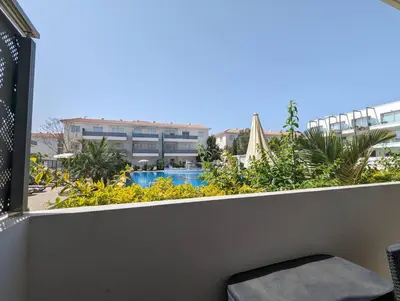 a balcony with a view of a pool and buildings at Violetta Apartment, Ground Floor Pool View in Paralimni