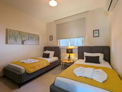 a bedroom with two beds and a couch at Violetta Apartment, Ground Floor Pool View in Paralimni