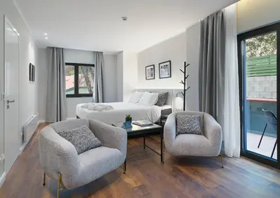 a bedroom with a bed and two chairs and a table at Le Vert Suites Platres in Platres