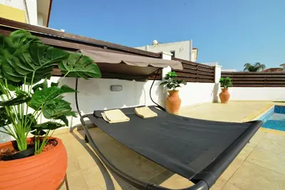 a hammock on top of a balcony with plants at Villa Thetida in Ayia Napa
