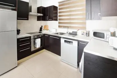 a kitchen with white appliances and brown cabinets at Villa Thetida in Ayia Napa