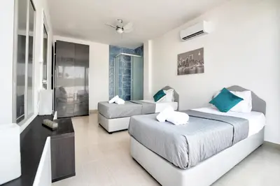 a hotel room with two beds and a television at Villa Thetida in Ayia Napa