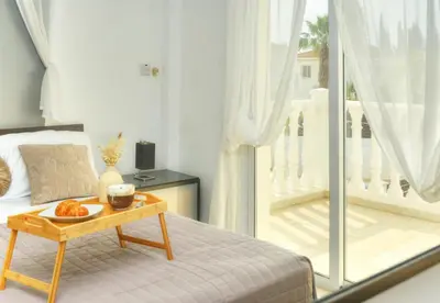a bedroom with a bed and a tray of fruit on a table at Villa Thetida in Ayia Napa
