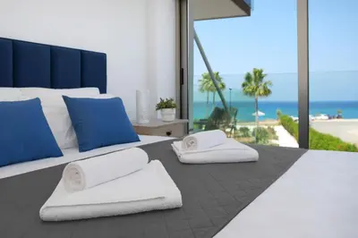 a bedroom with a bed with towels and the beach at Jenny - Beachfront Apartment in Protaras