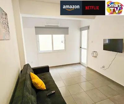 a living room with a couch and a tv at Heaven City Apartment, 150m from Chabad Lubavitch in Larnaka