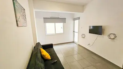 a living room with a couch and a television at Heaven City Apartment, 150m from Chabad Lubavitch in Larnaka