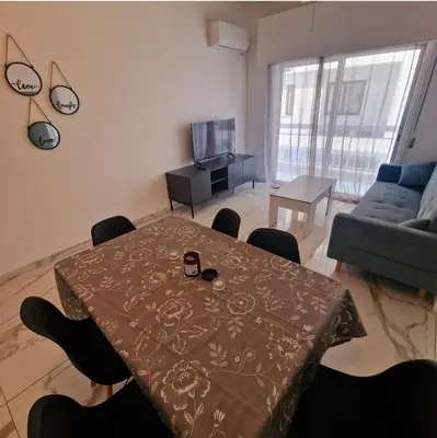 a living room with a table and a couch at Cozy 1 bedroom apartment Larnaca city-center F in Larnaka