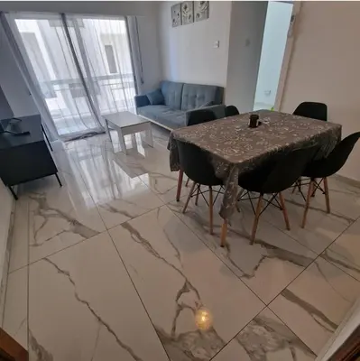 a living room with a table and a couch at Cozy 1 bedroom apartment Larnaca city-center F in Larnaka