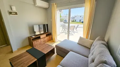 a living room with a couch and a tv at Beach Love BeachFront Apartment in Pyla