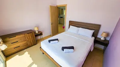 a bedroom with a large bed with two towels on it at Beach Love BeachFront Apartment in Pyla
