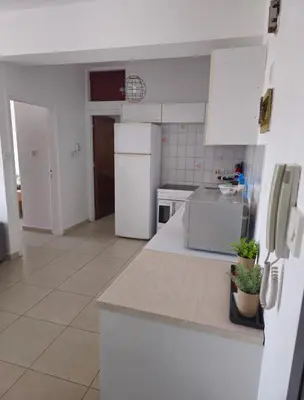 a kitchen with white appliances and white cabinets at The Heart of the City in Limassol