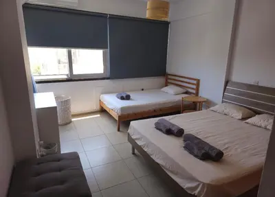 a bedroom with two beds and a couch and a window at The Heart of the City in Limassol