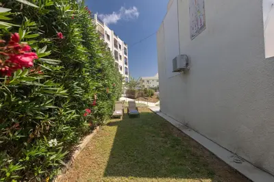 a hallway of a building next to a hedge at Pernera Nest in Protaras
