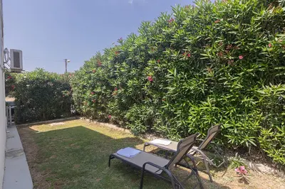 two chairs and a table in front of a bush at Pernera Nest in Protaras