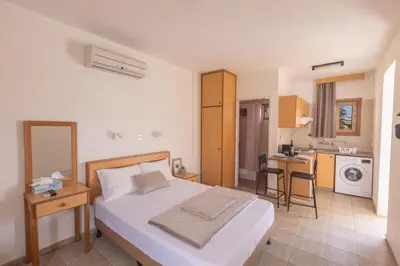 a bedroom with a large bed and a kitchen at Pernera Nest in Protaras
