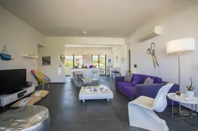 a living room with a purple couch and a table at Protaras Aster Seaside Suite in Protaras