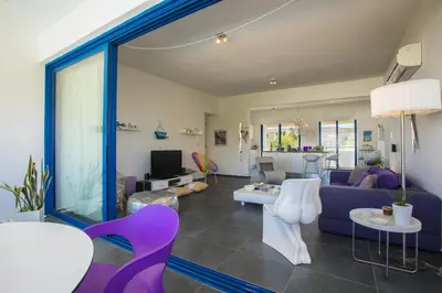 a living room with a purple couch and chairs at Protaras Aster Seaside Suite in Protaras
