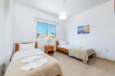 a bedroom with two beds and a window at Villa Amesta in Protaras