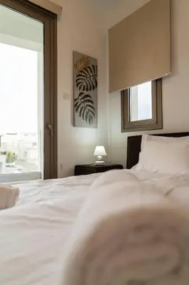 a bedroom with a white bed and a window at Hubstay - Seaview Villa Oriana in Larnaca in Larnaka