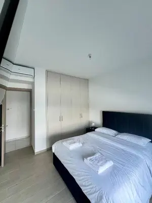 a bedroom with a large bed and white cabinets at Hubstay - Seaview Villa Oriana in Larnaca in Larnaka