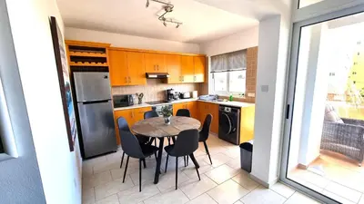 a kitchen with a table and chairs in it at Beach Haven: 7-Minute walk to the beach + Pool in Larnaka