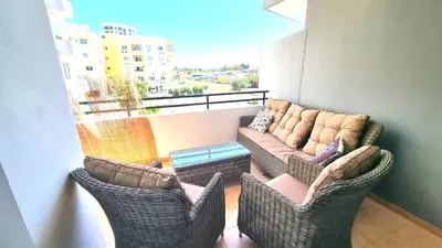 a balcony with two wicker chairs and a couch at Beach Haven: 7-Minute walk to the beach + Pool in Larnaka