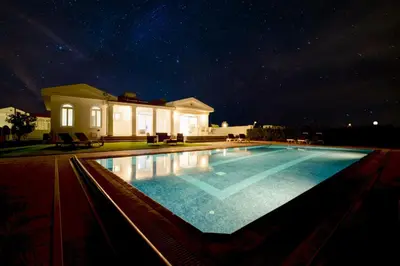 a swimming pool in front of a house at night at Villa Aquamarine in Ayia Napa