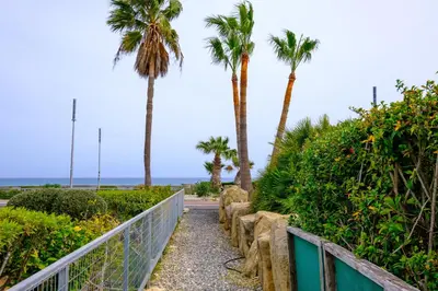a walkway to the beach with palm trees at Villa with private pool in Pervolia, Larnaca in Pervolia