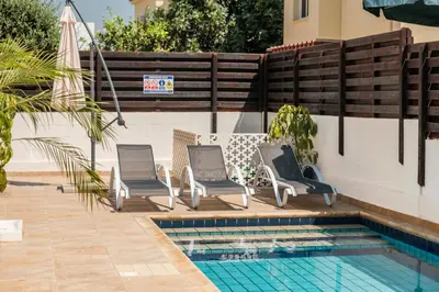 a group of chairs sitting next to a swimming pool at Mermaid Villa 16 in Ayia Napa
