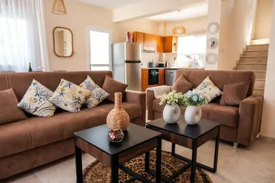 a living room with a couch and two tables with vases at Mermaid Villa 16 in Ayia Napa