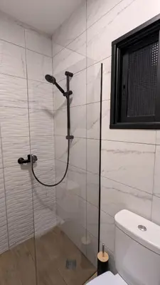 a glass shower in a bathroom with a toilet at Under the Palms in Nicosia