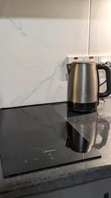 a tea kettle sitting on top of a stove at Under the Palms in Nicosia