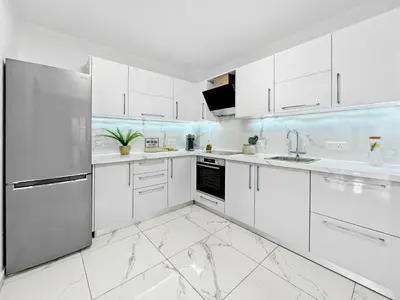 a white kitchen with white cabinets and appliances at The Encino - luxury seaside suite in Larnaka